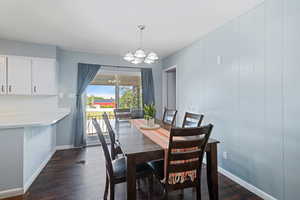 Dining room with dark wood-type flooring and a chandelier