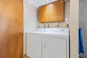 Washroom featuring cabinet space and separate washer and dryer