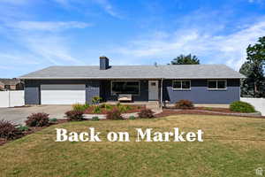 Single story home with brick siding, covered porch, concrete driveway, a chimney, and an attached garage