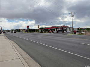 View of asphalt road with sidewalks, street lighting, and curbs