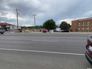 View of asphalt road featuring sidewalks and curbs