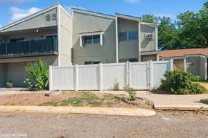 View of side of property with a gate and a balcony