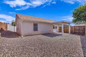 Back of property featuring stucco siding, a patio area, a tiled roof, and a fenced backyard