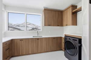 Laundry room featuring washer / clothes dryer, a mountain view, and cabinet space