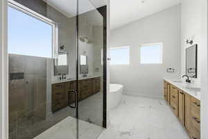 Full bath with double vanity, a soaking tub, a stall shower, and light marble finish flooring