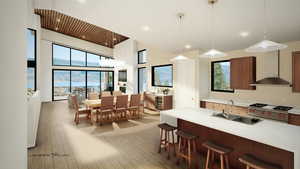Kitchen featuring premium range, wall chimney range hood, light countertops, light wood finished floors, and a high ceiling