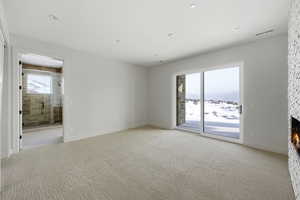 Empty room with a fireplace and light carpet