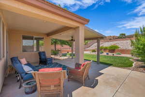 Fenced backyard with a patio area and a ceiling fan