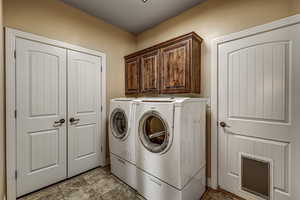 Laundry room with cabinets and storage closet
