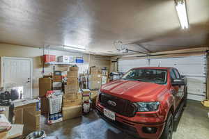 Garage with a garage door opener and a walk through door to back yard