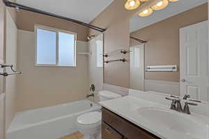 Full bathroom featuring tub / shower combination, vanity, a wainscoted wall, and tile patterned floors