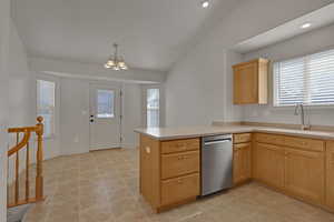 Kitchen with stainless steel dishwasher, healthy amount of natural light, a peninsula, light countertops, and recessed lighting