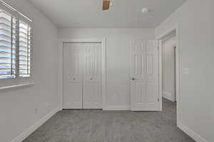Unfurnished bedroom with carpet floors, a closet, and ceiling fan