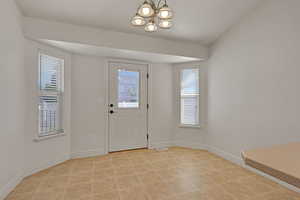 Foyer entrance with a chandelier and light tile patterned floors