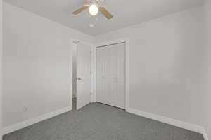 Unfurnished bedroom with carpet, a closet, and ceiling fan