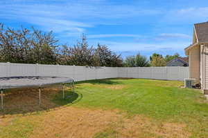 Fenced backyard with a trampoline