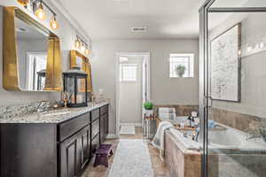 Bathroom with double vanity, a garden tub, a stall shower, and tile patterned flooring