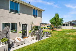 Back of house featuring a patio, stucco siding, a playground, and an outdoor living space with a fire pit
