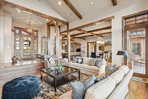 Living room featuring beam ceiling, light wood-style flooring, recessed lighting, coffered ceiling, and a chandelier
