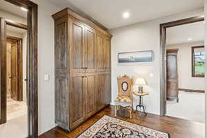 Corridor with dark wood-style flooring and recessed lighting