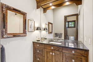 Bathroom with vanity and beam ceiling