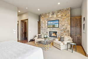 Carpeted bedroom featuring a fireplace and recessed lighting