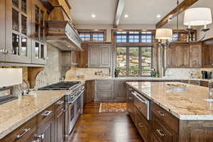 Kitchen with double oven range, beam ceiling, a warming drawer, custom exhaust hood, and dark wood-style floors