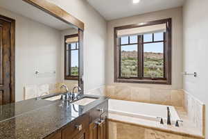 Full bathroom featuring healthy amount of natural light, vanity, a garden tub, and recessed lighting
