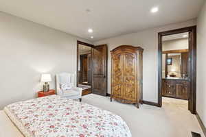 Bedroom with recessed lighting, light carpet, and connected bathroom