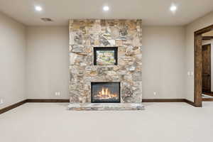 Unfurnished living room featuring carpet flooring, a fireplace, and recessed lighting