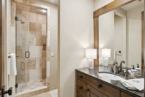 Full bath featuring vanity and a shower stall