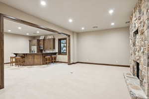 Living area featuring recessed lighting, wet bar, light carpet, and a fireplace