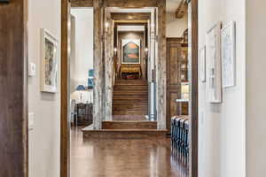 Hallway with stairway and wood finished floors