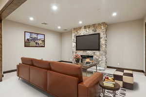 Carpeted living room with a fireplace and recessed lighting