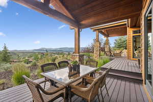 Wooden deck featuring a mountain view and outdoor dining area