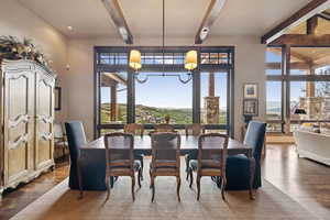 Dining room with beam ceiling, dark wood-style flooring, and a chandelier