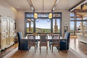 Dining room featuring wood finished floors, a mountain view, and beamed ceiling