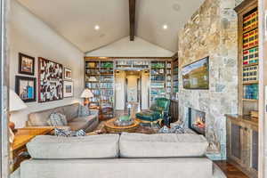 Living area with a stone fireplace and wood finished floors
