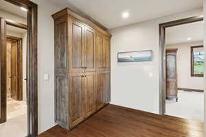Hall featuring dark wood-style flooring and recessed lighting