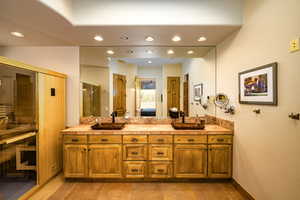 Ensuite bathroom with double vanity, recessed lighting, and a shower with shower door