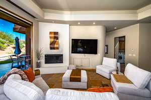 Living room featuring stone tile floors, a fireplace, and recessed lighting
