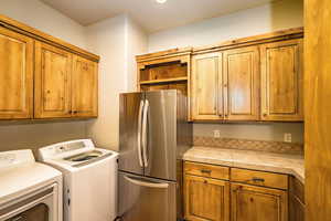 Laundry room featuring washer and clothes dryer and cabinet space