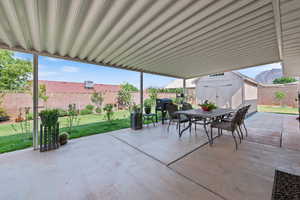 Fenced backyard featuring outdoor dining area, a storage shed, a patio, and a grill