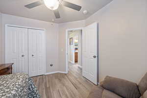 Bedroom with light wood-style floors, a closet, and ceiling fan