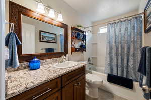 Bathroom featuring vanity, shower / bath combo with shower curtain, and tile patterned floors