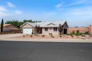 Ranch-style home with a tiled roof, driveway, stucco siding, and an attached garage