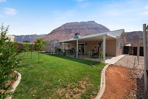 Back of property with a mountain view, stucco siding, and a patio area