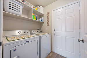 Laundry room featuring washer and clothes dryer and light wood-style floors