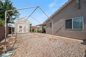 Fenced backyard featuring a storage shed and a patio