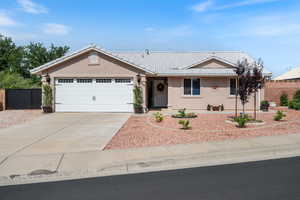 Ranch-style home with a tile roof, stucco siding, concrete driveway, and a garage